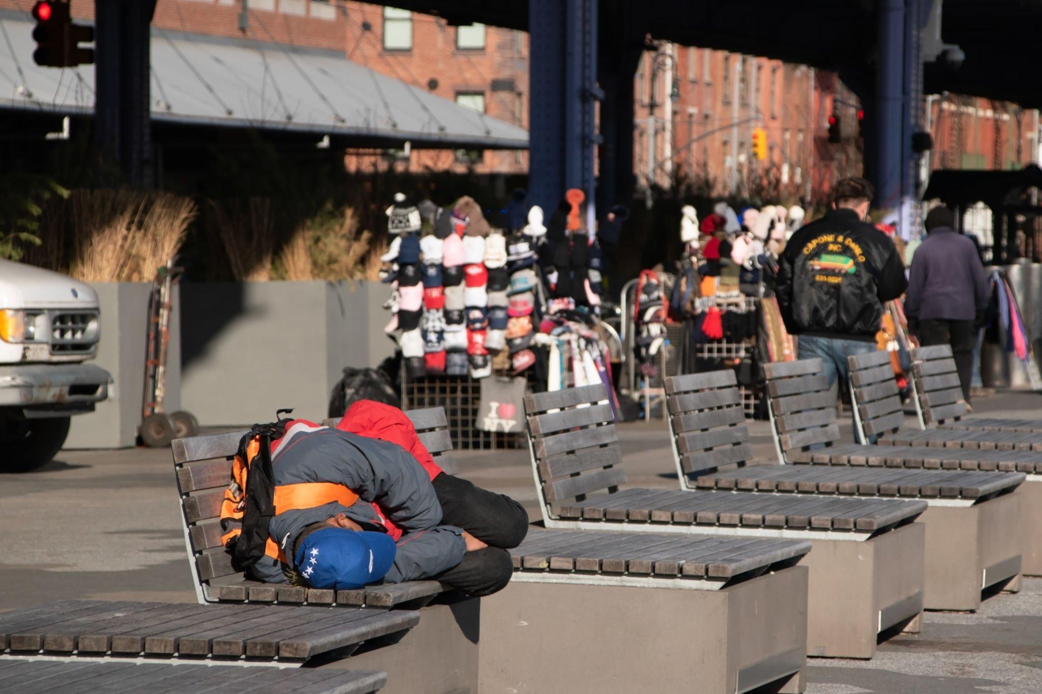 Homeless person sleeping on a bench